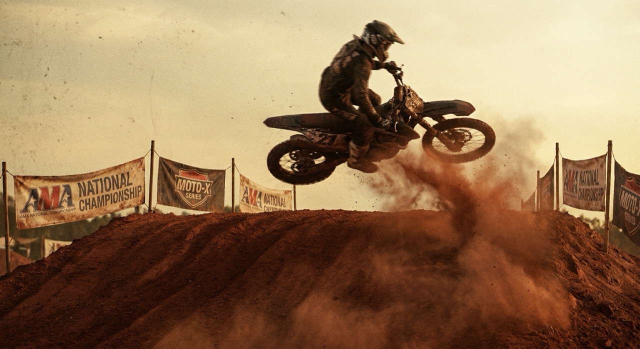 A motocross bike mid-air over a tabletop jump